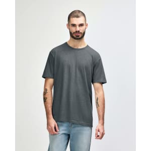 A man wearing a dark grey Gildan Softstyle adult T-shirt, paired with light blue jeans. The t-shirt has a logo.