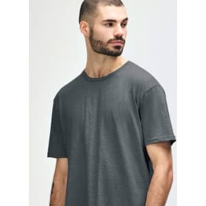 A model wearing a Gildan Softstyle adult t-shirt in dark grey with a round neckline and short sleeves.