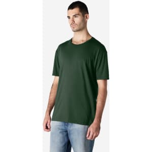 A dark green Gildan Softstyle adult t-shirt on a male model, paired with light blue jeans, featuring a logo.
