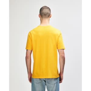 A plain orange Gildan Softstyle adult T-shirt displayed on a model from the back. The shirt features a logo.