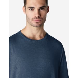 A navy blue Gildan Softstyle adult t-shirt on a male model, featuring a casual crew neck design and a plain backdrop.