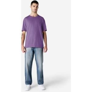 A man wearing a purple Gildan Softstyle adult t-shirt and light blue jeans, standing against a plain background.