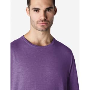 A man wearing a purple Gildan Softstyle adult T-shirt, featuring a round neckline and short sleeves.