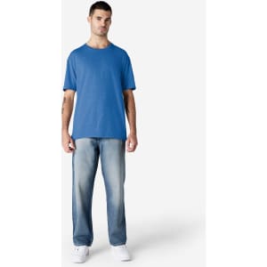 A model wearing a blue Gildan Softstyle adult T-shirt paired with light blue jeans and white shoes.