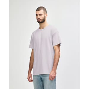 A light grey Gildan Softstyle adult T-shirt displayed on a model, featuring a relaxed fit and no visible logo.