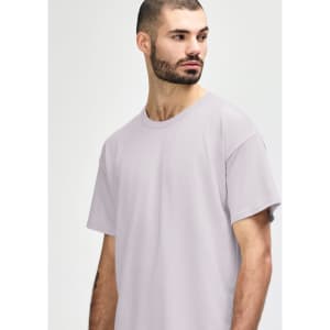 A light grey Gildan Softstyle adult t-shirt with a round neckline displayed on a male model. It features a brand logo.