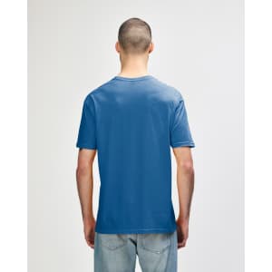 A back view of a man wearing a blue Gildan Softstyle adult t-shirt. The shirt has a logo on the back.