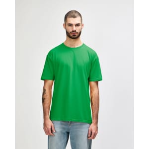 A green Gildan Softstyle adult t-shirt displayed on a model, featuring a plain design and a label.