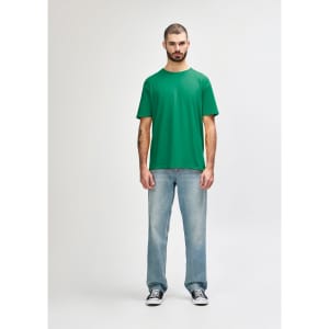 A green Gildan Softstyle adult t-shirt displayed on a male model, paired with light blue jeans.