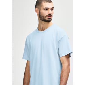 A light blue Gildan Softstyle adult t-shirt featuring short sleeves and a round neckline, modelled by a male.