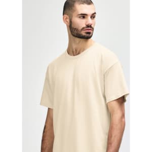 A light beige Gildan Softstyle adult t-shirt featuring a crew neck and short sleeves, displayed on a male model.