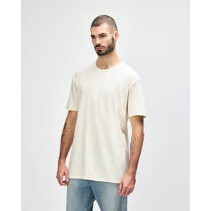A white Gildan Softstyle adult T-shirt displayed on a model, paired with casual blue jeans.