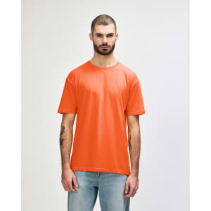 An orange Gildan Softstyle adult T-shirt on a model, featuring a simple design and a crew neckline.