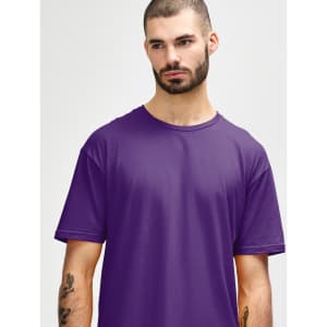 A man is wearing a purple Gildan Softstyle adult t-shirt, displaying a relaxed neckline and a casual style.