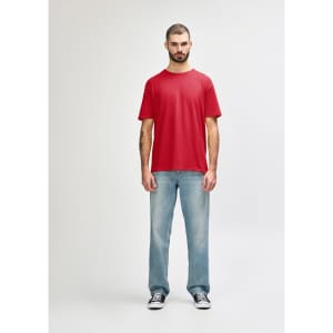 A red Gildan Softstyle adult T-shirt displayed on a male model, paired with light blue jeans. The shirt features a logo.