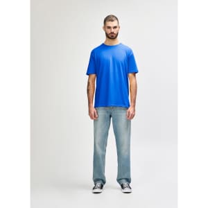 A blue Gildan Softstyle adult T-shirt displayed on a model wearing light blue jeans and white shoes.