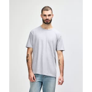 A model wears a grey Gildan Softstyle adult T-shirt featuring a relaxed fit and a crew neckline.