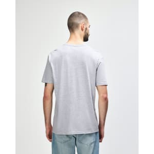 A grey Gildan Softstyle adult T-shirt displayed on a model, featuring a relaxed fit and short sleeves.