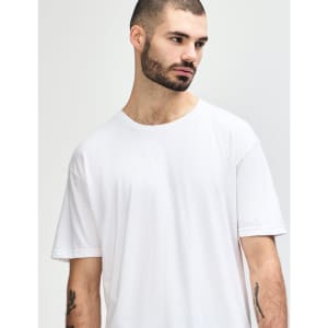 A white Gildan Softstyle adult T-shirt displayed on a model with a neutral background, featuring a logo.