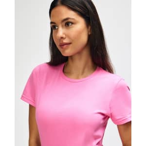 A pink Gildan Softstyle ladies' t-shirt displayed on a model, featuring a round neckline and short sleeves.