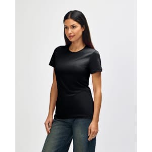 A black Gildan Softstyle ladies' t-shirt displayed on a model, side view, with blue jeans. The shirt has a logo.