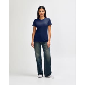A navy blue ladies' T-shirt paired with light blue jeans and white sneakers. The shirt features a logo.