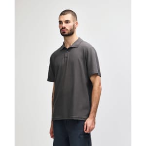 A man wearing a grey Gildan Softstyle Adult Double Pique Polo, standing against a plain background.