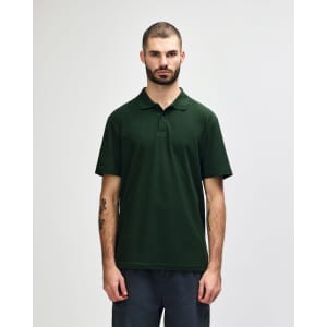 A green and navy polo shirt with a collar, displayed on a male model. The shirt features a logo.