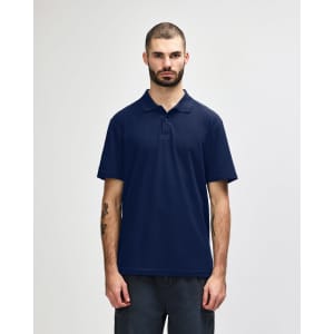 A model wearing a navy blue Gildan Softstyle Adult Double Pique Polo. The polo has a logo on it.