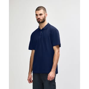 A model wearing a navy blue Gildan Softstyle Adult Double Pique Polo with a logo on the chest.
