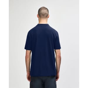 A navy blue adult polo shirt is displayed from the back, featuring short sleeves and a collar. It has a logo on it.