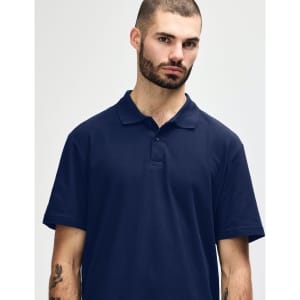A man wearing a navy blue Gildan Softstyle Adult Double Pique Polo with a collar and buttons.