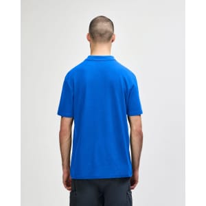 A blue Gildan Softstyle adult double pique polo shirt, featuring a logo on the back.
