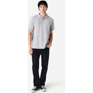 A light grey polo shirt with short sleeves, paired with black trousers and casual shoes. The shirt features a logo.