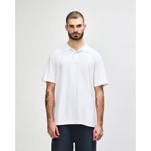 A white short-sleeve polo shirt on a model, featuring a collar and a logo.