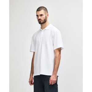 A model wearing a plain white double pique polo shirt, featuring a subtle logo on the chest.