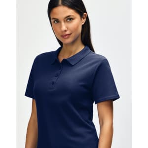 A woman is wearing a navy blue Gildan Softstyle Ladies' Double Pique Polo, featuring a collar and buttons.