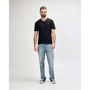 A black Gildan Softstyle adult v-neck t-shirt displayed on a model, paired with black jeans and sneakers.