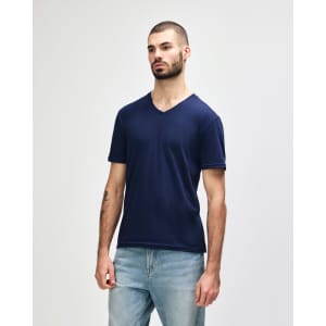 A navy Gildan Softstyle adult v-neck t-shirt on a model, featuring a logo on the shirt.