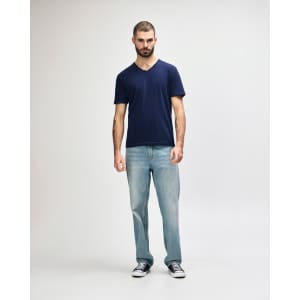 A navy blue Gildan Softstyle adult V-neck T-shirt displayed on a model, paired with black jeans and sneakers.