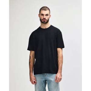 A black Gildan Softstyle adult midweight T-shirt displayed on a model, featuring a simple design and no visible logo.