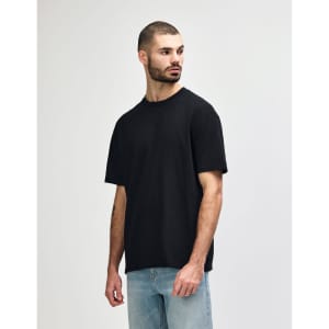 A black midweight t-shirt displayed on a model, featuring a simple design and a logo.