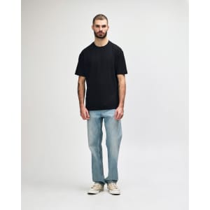 A black midweight t-shirt displayed on a model, paired with black jeans and sneakers. Features a logo.