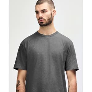 A grey midweight T-shirt featuring a crew neck and short sleeves, worn by a model with tattoos.