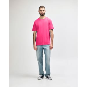 A model wearing a vibrant pink Gildan Softstyle Midweight T-Shirt paired with black jeans and sneakers.