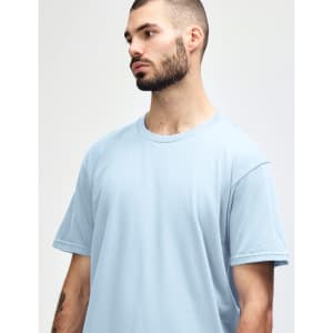 A men’s midweight T-shirt in light blue, featuring short sleeves and a round neckline. It has a small logo.
