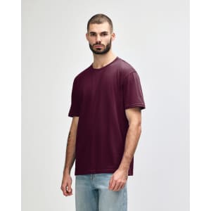 A burgundy Gildan Softstyle Adult Midweight T-Shirt displayed on a model, featuring a branding logo.