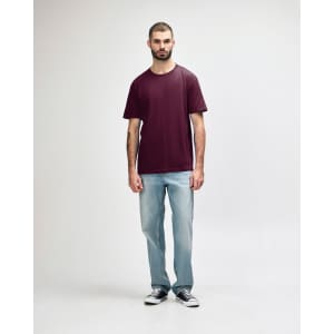A maroon Gildan Softstyle adult midweight T-shirt displayed on a model, paired with black jeans and sneakers.