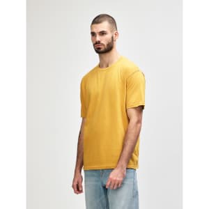 A mustard-coloured Gildan Softstyle adult midweight T-shirt displayed on a model, featuring a logo.