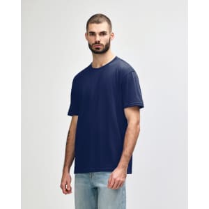 A navy blue Gildan Softstyle adult midweight T-shirt on a model, featuring a logo on the sleeve.
